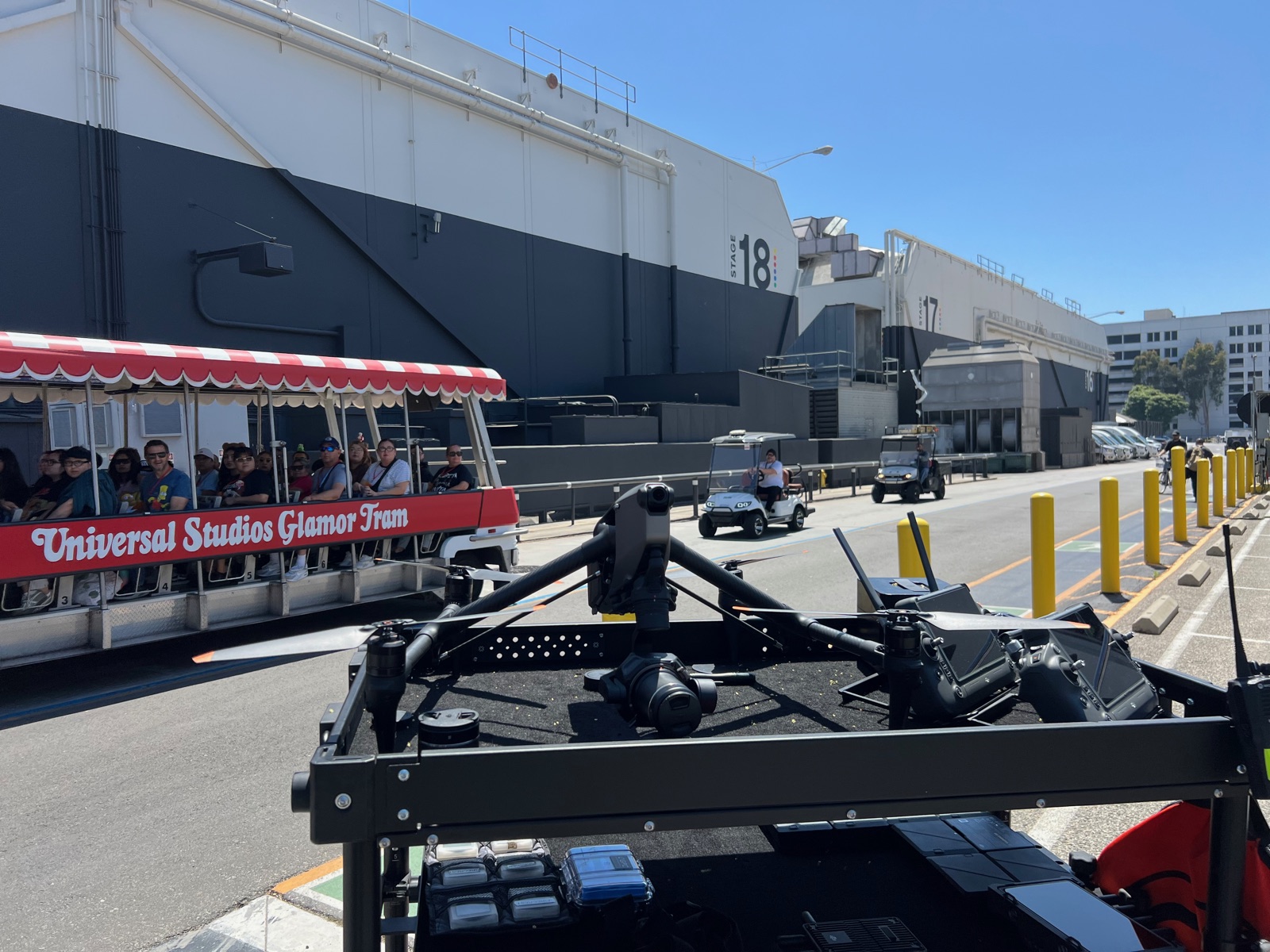 DJI Inspire 3 staged on the drone cart on the Universal Studios backlot, with a studio tour tram and soundstages behind it, while shooting Based on a True Story