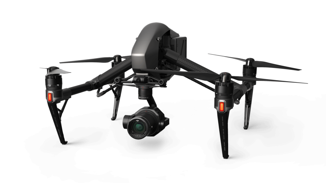DJI Inspire 2 in landed stance with dark gray body, carbon fiber arms, and red LED accents